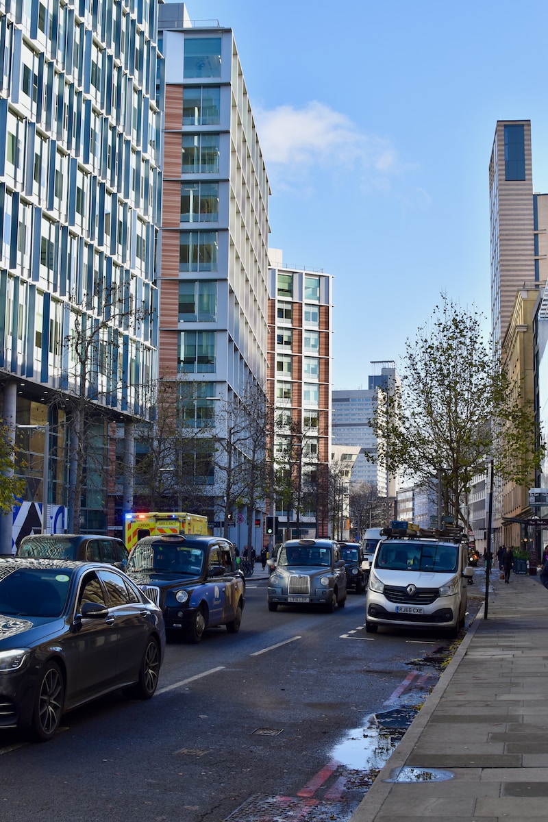 a city street filled with lots of traffic next to tall buildings