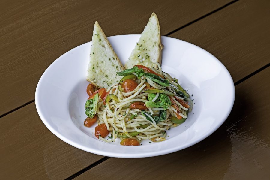 Pasta in the white bowl with two breads