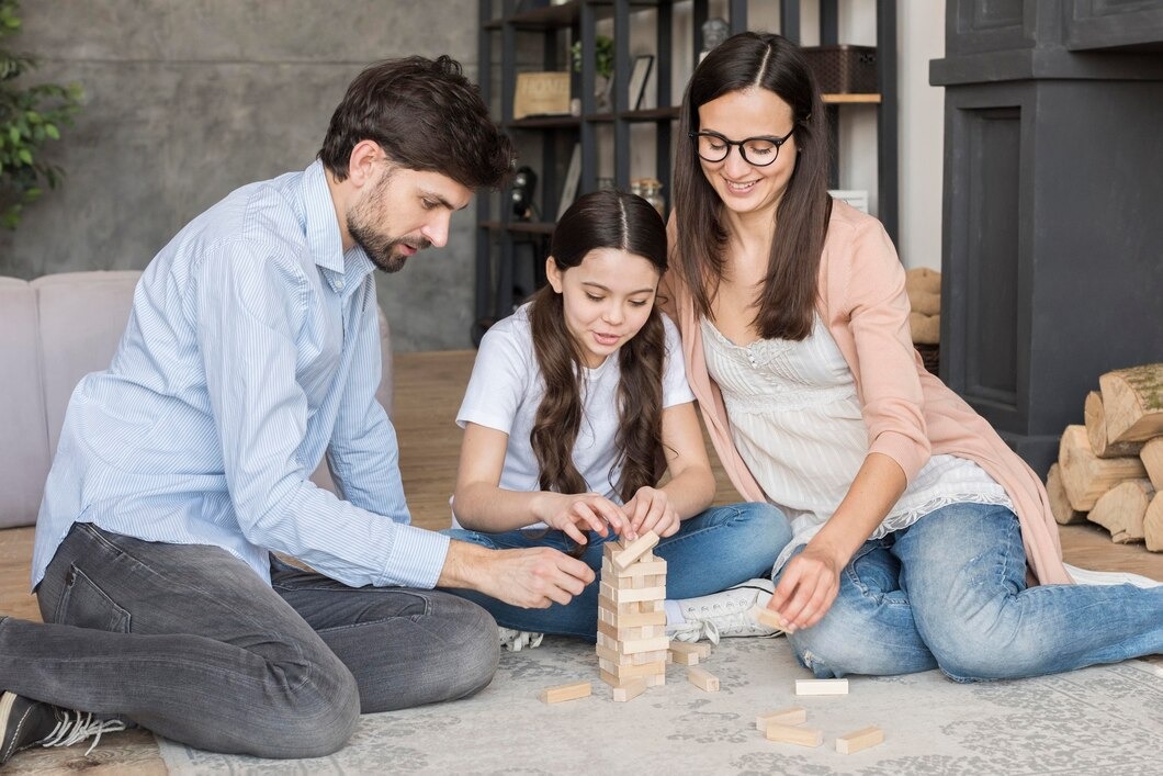 A family joyfully playing together, building structures with colorful wooden blocks on a bright, sunny day